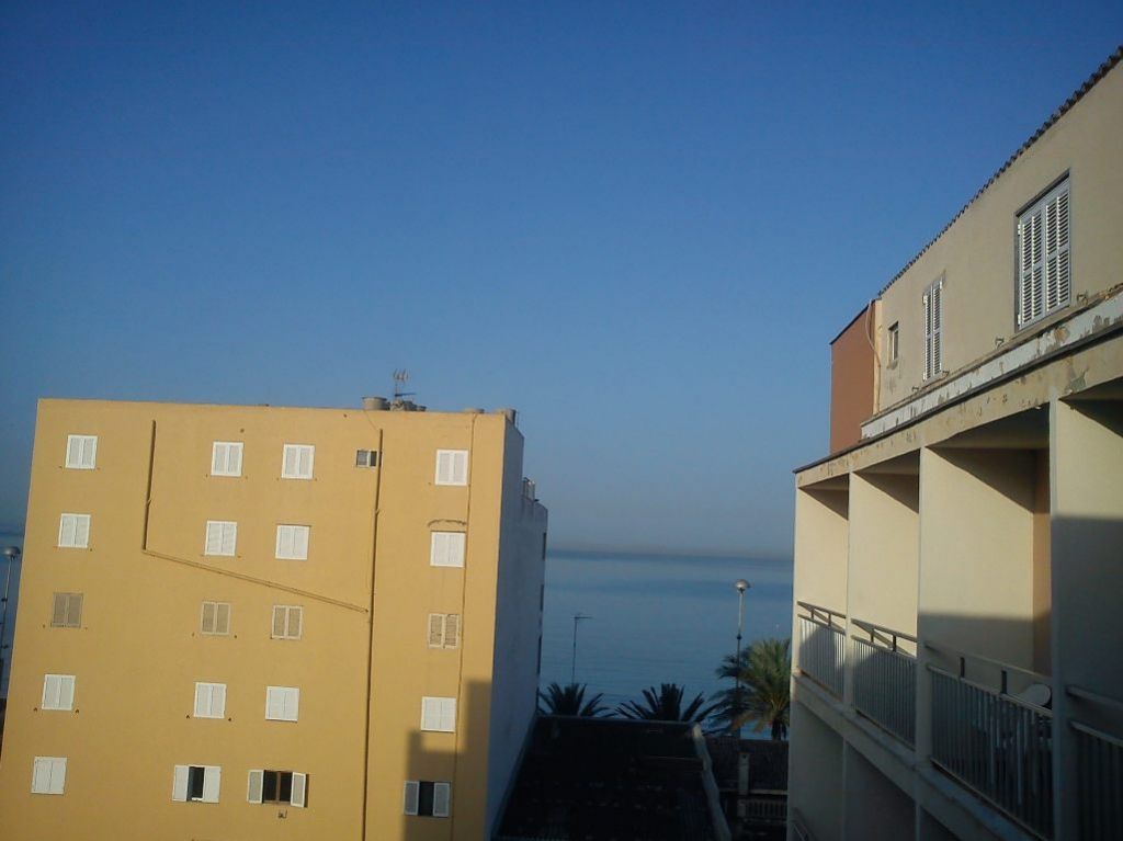 Pohľad z balkónu na more a modrú oblohu naznačuje pekný deň.